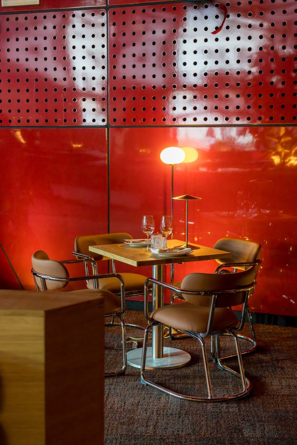 Mesa con copas de vino junto a la pared roja