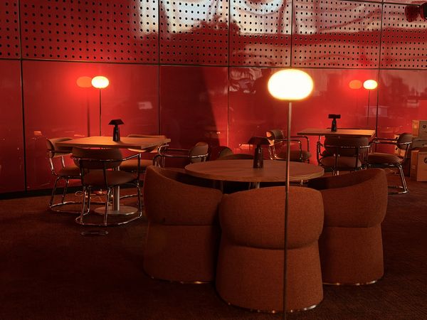 La sala de NUBEL de noche, junto a la pared roja
