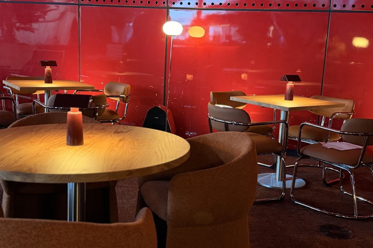 Mesa de NUBEL con luz cálida junto a la pared roja